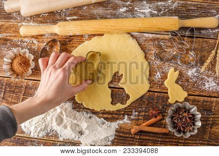 The Girl Cuts Out Of The Dough Curly Cookies. Easter Cookies On A Wooden Background. Beautiful Still
