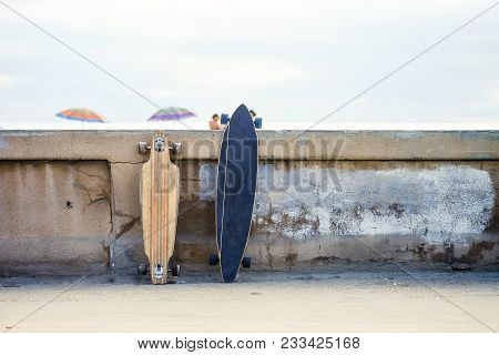 Skateboards Leaning On The Curb, Neat The Beach. San Diego, California