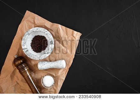 White Mortar And Pestle With Dried Peppers In Flat Lay On Black Background. Copy Space. Still Life. 