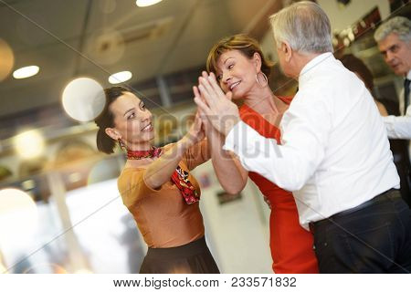 Group of senior people in dancing class with dance teacher