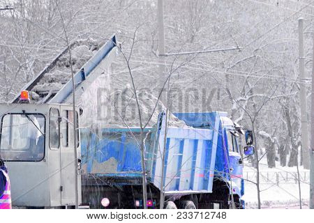 Front View Of Snowplow Service Truck And Gritter Spreading Salt On The Road Surface To Prevent Icing