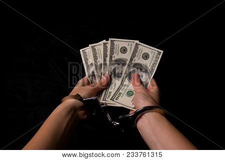 Women's Hands In Handcuffs With Dollars