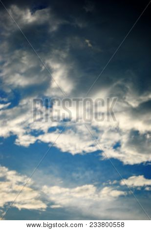 A Blue Sky Filled With Dark And Light Clouds, Hiding The Sun.