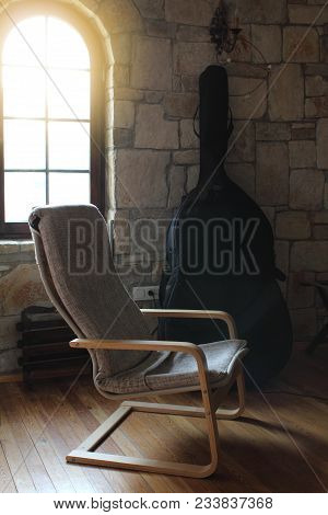 Vintage Wooden Chair Near The Window In The Room With The Double Bass
