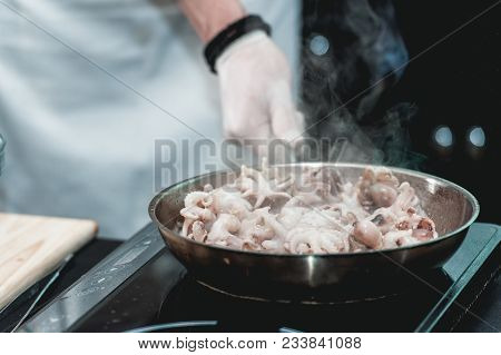 The Chef Cooks Small Octopus On A Metal Frying Pan At The Restaurant To Make Brazilian Dish.