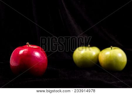 Red And Two Green Apples On A Black Background