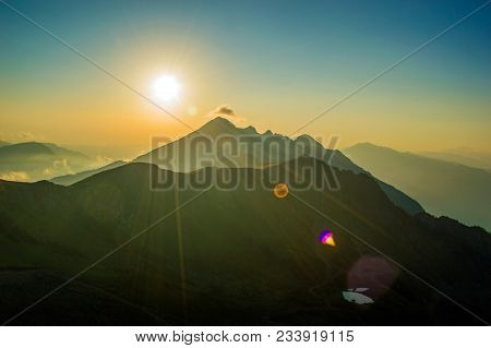 Yellow Beautiful Sunset In The Mountains Sun Rays, Clouds And Fog