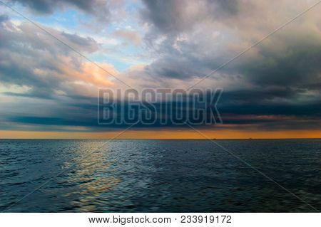 The Sea Surface Of The Ocean At Sunset Orange, Clouds And Clouds In The Evening Storm