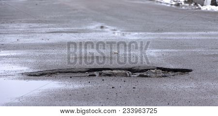 There Are Many Potholes On The Roadway Close-up