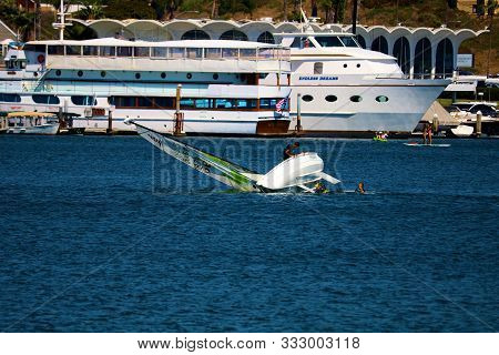 August 25, 2019 In Newport Harbor, Ca:  Dinghy Sail Boat Capsizing As Someone Is Learning To Sail In
