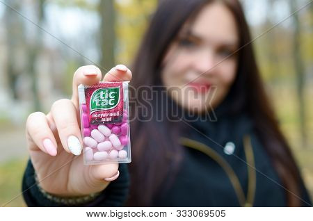 Kharkov, Ukraine - October 26, 2019: Young Woman Shows New Tic Tac Hard Mints Package In Autumn Park