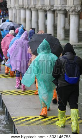 Plastic Special Gaiters Or Leggings And Waterproof Clothes And Tourists During A Visit To Venice In 