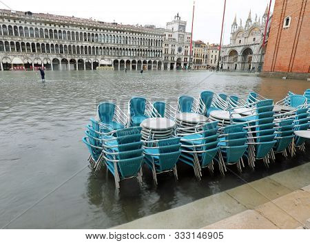 Chairs And Tables Submerged By High Water During The High Tide In Venice In Saint Mark Square