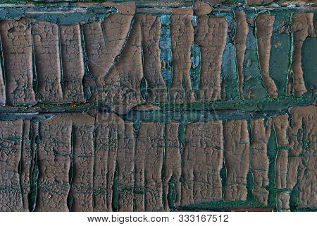Part Of A Wooden Panel Peeling Off Under The Influence Of Weather And Time. Fragment Of An Urban Tex