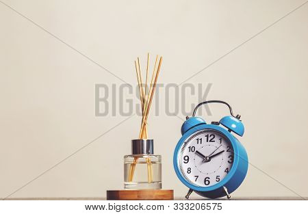 Bottle Of Fragrance Diffuser With Sticks And A Vintage Clock Isolated . Air Freshener . Relaxation T