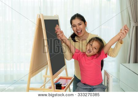 Happy Successful Asian Kindergarten Student And Her Mother Hands Raised Up To Celebrate The Successf