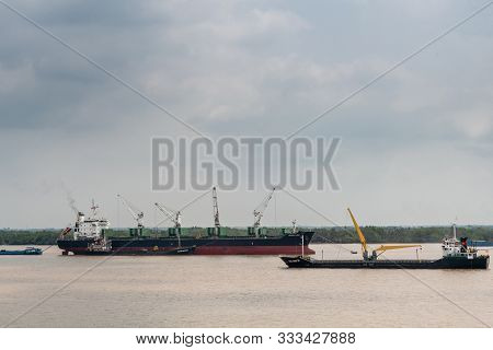 Ho Chi Minh City, Vietnam - March 12, 2019: Long Tau River. Densa Hawk Bulk Carrier Uses Its Cranes 