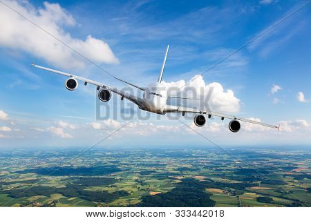 White Passenger Plane In Flight. The Plane Flies Against A Background Of A Endless Horizon. Aircraft