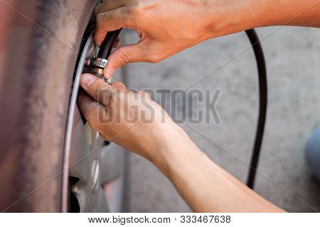 Close Up Hand Of Man Inflating Tire.
