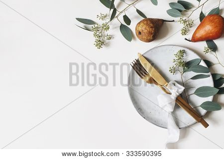 Autumn Thanksgiving Table Place Setting. Golden Cutlery, Porcelain Plate, Berry Eucalyptus Leaves An