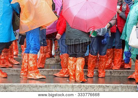 People With Rain Coat And Gaiters During Flood In Venice
