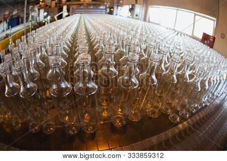 Glassworks. Glass Industry. Many Glass Bottles On A Factory Conveyor.