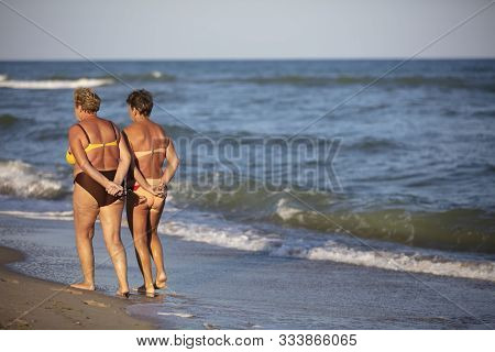 Ukraine, August 30, 2019. Odessa. City Beach. Ordinary Elderly Women Walk Along The Seashore. Relax 