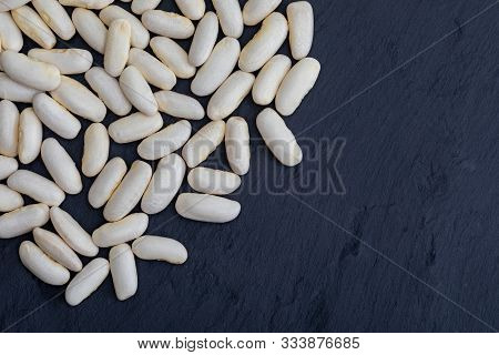 White Beans (fabes) Raw (legume) On Black Slate Background With Texture. With Space To Insert Your T