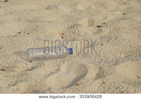 Garbage Plastic Bottles That Fall On The Beach.