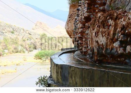This Falaj Runs On The Edge Of The Mountain In Oman