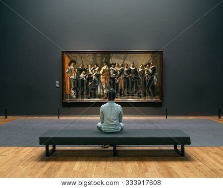 Amsterdam, Netherlands - July 20, 2019: Art Lover Admire The Painting In Rijksmuseum