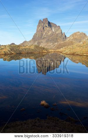Midi Dossau Peak reflected in a lake. Ossau Valley, Pyrenees National Park, Pyrenees, France.