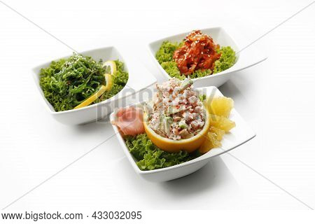 Composition Of Oriental Appetizers In Bowls, Isolated On A White Background. A Pickled Seagrass Japa
