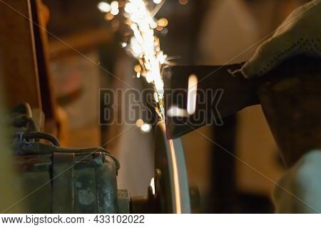 Sharpen The Knife On The Abrasive Wheel, Sparks Fly From Grinding Metal.