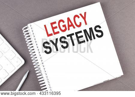 Legacy Systems Text On Notebook With Calculator And Pen