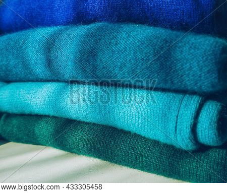 Close Up View Of Organized Stack Of Blue To Green Gradient Cachemire Clothes