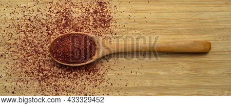 Ground Organic Aromatic Sumac Texture In Wooden Spoon On Bamboo Cutting Board