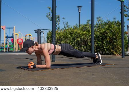 Sportive Woman Working Out On The Sports Ground In Sunny Summer Day