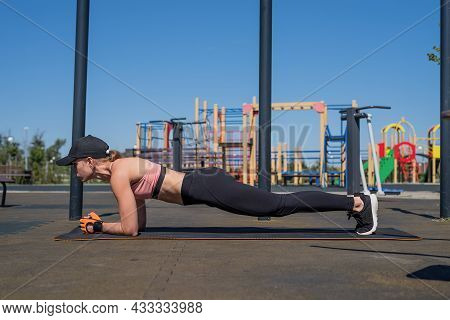 Sportive Woman Working Out On The Sports Ground In Sunny Summer Day