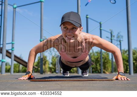 Sportive Woman Working Out On The Sports Ground In Sunny Summer Day