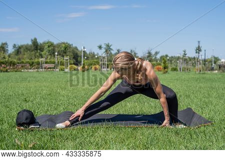 Sportive Woman Working Out In The Park In Sunny Summer Day