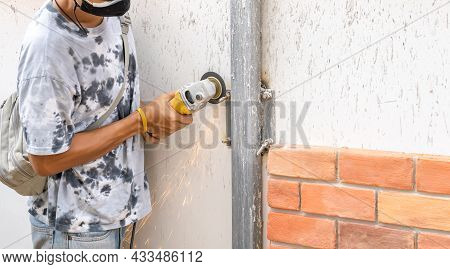 Asian Worker Young Man Sawing And Kept Detailed Metal Screw From A Steel Pole For Preparing To Insta