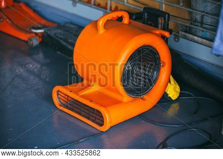 Orange Blower Fan Machine On Wet Floor. Heavy Duty Industrial Portable Blower Fan On Floor \nused To