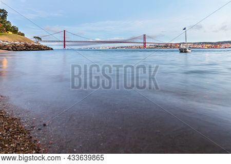 The 25 De Abril Suspension Bridge Over Tagus River In Lisbon, Portugal At Sunrise