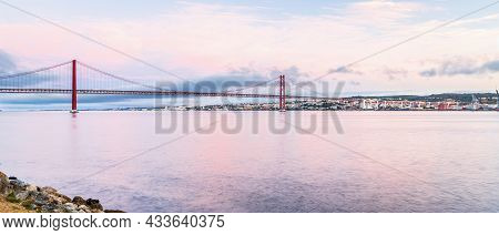 The 25 De Abril Suspension Bridge Over Tagus River In Lisbon, Portugal At Sunrise