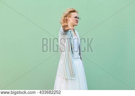 Stop It. Portrait Of Serious Young Blonde Woman In White Shirt, Skirt, And Striped Blouse With Eyegl