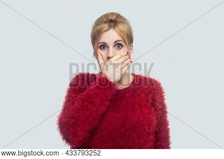 Portrait Of Shocked Silence Beautiful Young Blond Woman In Red Blouse Standing, Covering Her Mouth A