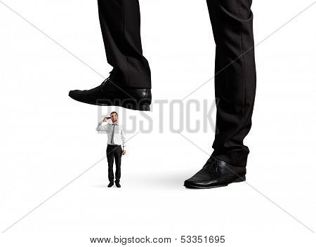 small desperate businessman with gun under big leg his boss. isolated on white background