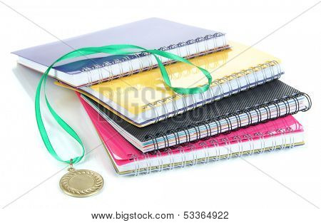 Medal for achievement in education and notebooks isolated on white