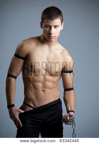 athletic man dance striptease with chain